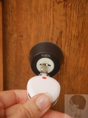 ChecKEYⅡを取り付けた鍵をLIXIL製の玄関扉に差し込んでいる