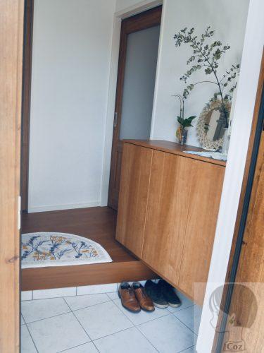 玄関扉から、白タイルの玄関内の部屋の中を見た様子