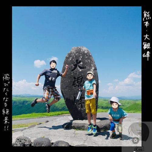 熊本　大観峰の石碑の前でジャンプする親子づれ