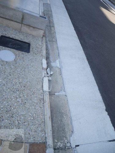 新築の家と道路の間の縁石ブロックが破損