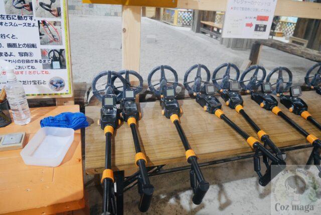 岐阜博石館の鉱山体験館内にあるトレジャーハンティングで探す金属プレートを探すための金属探知機がたくさん机に並んでいる